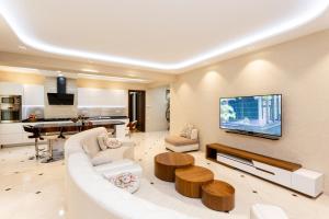 a living room with a white couch and a tv at Luxury Apartment in The City Centre lll in Tbilisi City