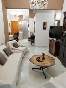 ein Wohnzimmer mit einer weißen Couch und einem Tisch in der Unterkunft Comfy Apartment For 4 Ppl In Koukaki in Athen