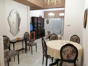 ein Esszimmer mit Tisch und Stühlen und einem Spiegel in der Unterkunft Comfy Apartment For 4 Ppl In Koukaki in Athen + 12 Fotos