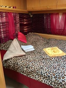 a bed with two pillows and a book on it at Caravan on the beach, pet friendly in Corbu