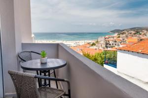 a table and chairs on a balcony with a view of the ocean at Le Vieux Quartier in Limenaria