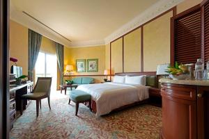 a hotel room with a bed and a desk and chair at The Empire Brunei in Bandar Seri Begawan