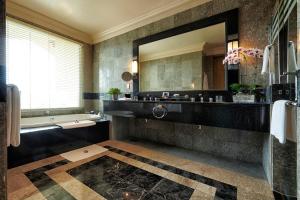 a bathroom with a tub and a large mirror at The Empire Brunei in Bandar Seri Begawan