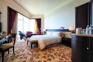 a hotel room with a large bed and a desk at The Empire Brunei in Bandar Seri Begawan
