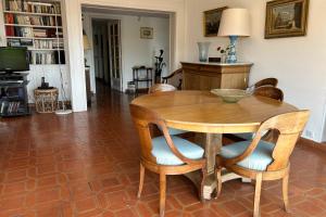 胡安萊潘的住宿－Lovely 4-person apartment 200 m from beaches Cap d'Antibes，一间带木桌和椅子的用餐室