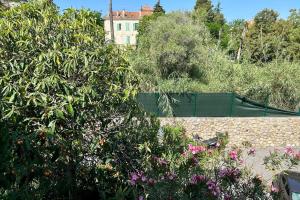 a garden with flowers and a building in the background at Lovely 4-person apartment 200 m from beaches Cap d'Antibes in Juan-les-Pins