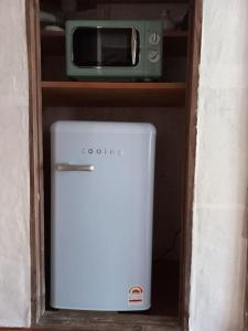 un piccolo forno a microonde posto sopra un frigorifero di Yasun Gallery a Gyeongju