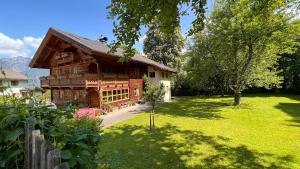 a large wooden house with a green yard at Appartement am Mühlrain in Saalfelden am Steinernen Meer