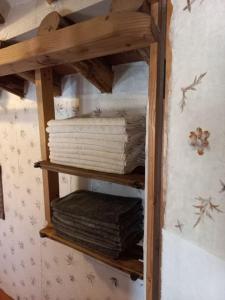 a wooden shelf with folded towels on a wall at Yasun Gallery in Gyeongju