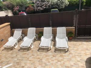 a group of white chairs sitting on a patio at Casa Narciso - Mondello in Mondello