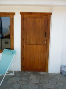 a wooden door in a room with a blue chair at Acogedor apartamento con fantásticas vistas. in La Zubia