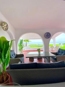 a living room with couches and a table at Villa avec jardin sur la plage - Complexe Al Amine in Fnidek