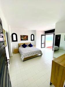 a bedroom with a bed on a tiled floor at Villa avec jardin sur la plage - Complexe Al Amine in Fnidek