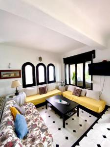 弗尼迪克的住宿－Villa avec jardin sur la plage - Complexe Al Amine，客厅配有两张沙发和一张桌子