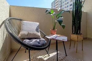 a wicker chair sitting on a balcony with a plant at Стильная квартира в новостройке in Baku