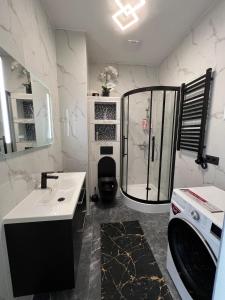 y baño con ducha, aseo y lavamanos. en Krasta Home apartament Free Parking With CITY & RIVER VIEW, en Riga