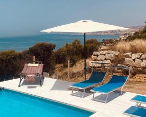 einen Pool mit 2 Stühlen und einem Sonnenschirm in der Unterkunft Locazione Turistica Il Tucano in Agrigento