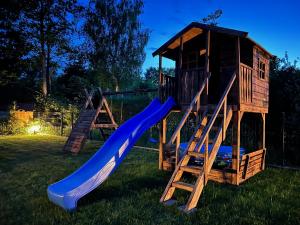 un parque infantil con tobogán y una casa de juegos en UNO Dom Kopalino en Kopalino