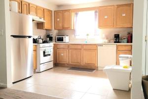 a kitchen with wooden cabinets and a white refrigerator at Emerald Guest Room 2C in Newark