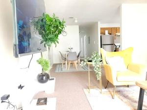 a living room with yellow furniture and plants in it at Emerald Guest Room 2C in Newark