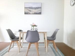 a dining room table with three chairs and a vase on it at Emerald Guest Room 2C in Newark