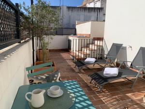 a patio with a table and chairs on a balcony at La Casa del Pintor Apartments in Seville