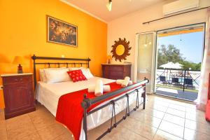 a bedroom with a bed and a window with a balcony at Angelloti Exclusive Beach Villa in Ágios Matthaíos