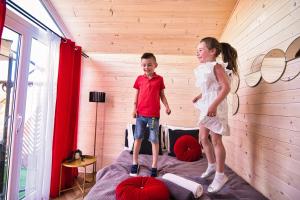 Ein Junge und ein Mädchen stehen auf einem Bett in der Unterkunft Holiday Park Zator Resort & Spa in Zator
