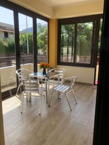 - une salle à manger avec une table, des chaises et des fenêtres dans l'établissement Casa Narciso - Mondello, à Mondello