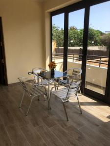a table and chairs in a room with a balcony at Casa Narciso - Mondello in Mondello