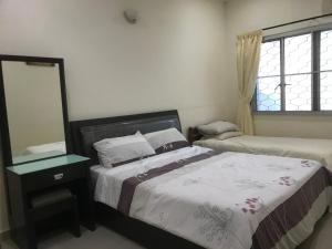 a bedroom with two beds and a mirror and a window at Carols Guesthouse near Jonker and Satay Celup in Malacca