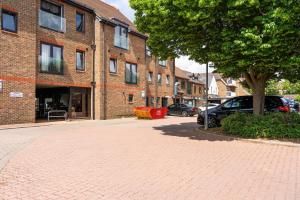 a brick road in front of a building with a tree at Livestay-One Bed Apt in Slough with FREE Parking in Slough