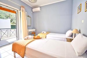 two beds in a room with a window at Angelloti Exclusive Beach Villa in Ágios Matthaíos +43 photos