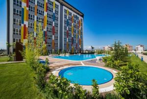 a large apartment building with a large swimming pool at Selin's apartment with pool view in Antalya