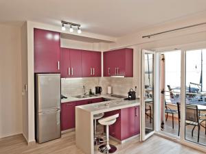 a kitchen with purple cabinets and a dining room at Sea Sparkle 1b in Preveza