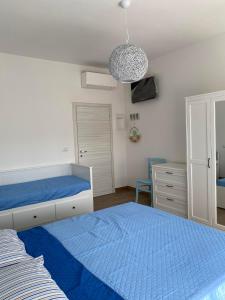 1 dormitorio con 2 camas y lámpara de araña en B&B Nonna Maria, en Porto Garibaldi