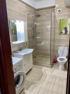 a bathroom with a shower and a toilet and a sink at Belle Sea View Apartment Mamaia in Mamaia