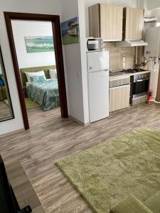 a kitchen with a refrigerator and a bed in a room at Belle Sea View Apartment Mamaia in Mamaia