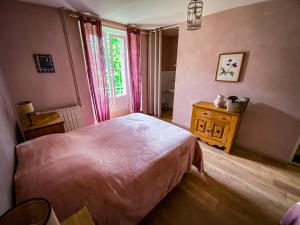 een slaapkamer met een groot bed en een raam bij Lisons des Sources in Nans-sous-Sainte-Anne