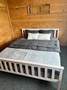 a white bed in a room with a wooden wall at Edelweiss 4 Zi Ferienwohnung in Landhaus in Frutigen