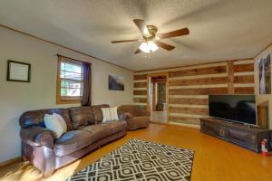a living room with a couch and a flat screen tv at Porch and Fire Pit Family-Friendly Afton Cabin! in Greeneville