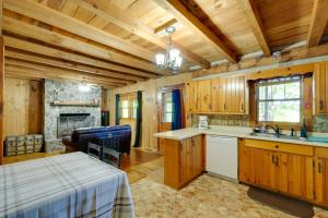 a kitchen with wooden cabinets and a fireplace at Porch and Fire Pit Family-Friendly Afton Cabin! in Greeneville