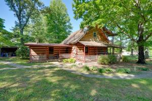 una cabaña de madera en el bosque con un patio en Family-Friendly Afton Cabin with Spacious Yard!, en Greeneville