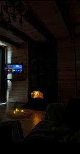 a dark room with a fireplace with a tv at Mavera Suit Bungalow in Ardeşen