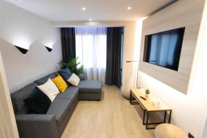 sala de estar con sofá y TV en Apartamento Milano Living Suites en Vila real, en Villareal