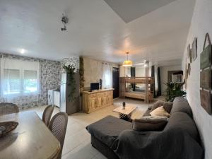 uma sala de estar com um sofá e uma mesa em Apartamento loft, jardín y piscina privada em Romanyá de la Selva