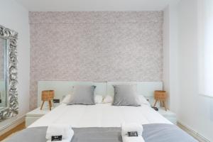 um quarto com uma cama branca e 2 cadeiras em Tiboli apartment by People Rentals em Bilbao