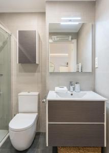 uma casa de banho com um WC, um lavatório e um espelho. em Tiboli apartment by People Rentals em Bilbau