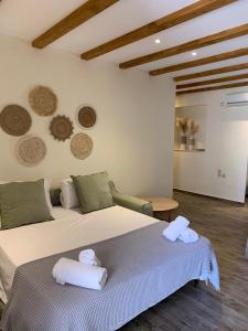 1 dormitorio con 1 cama grande y toallas. en Mangata suites homes with private pools, en Meganisi