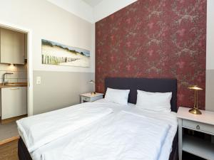 ein Schlafzimmer mit einem weißen Bett und einer roten Wand in der Unterkunft Villa Amelia, App. 06 in Heringsdorf